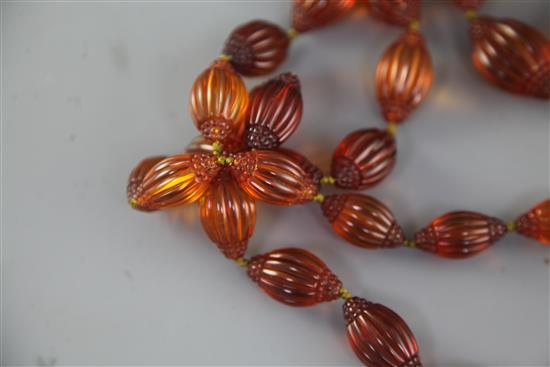 A Chinese amber necklace overall 66in.. sold with a copy of the catalogue